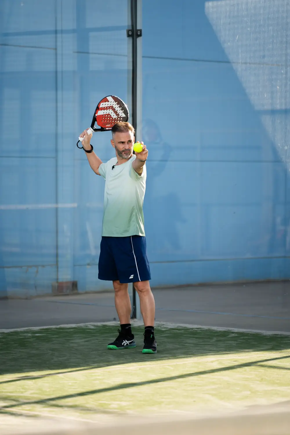 Iván Osuna, founder and head coach of OSU Padel, about to serve on an outdoor padel court