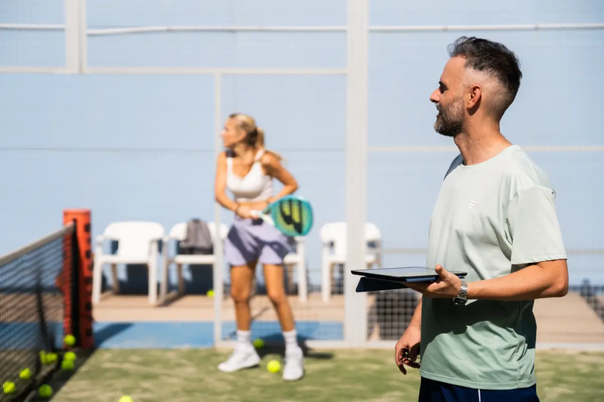 Iván entrenando a una jugadora en pista durante una clase de pádel en Valencia